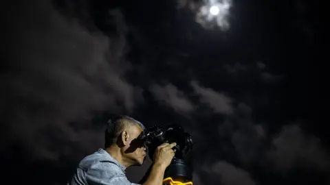 Getty Images A man installs a telescope in Indonesia