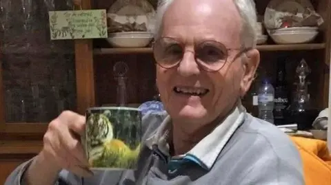 Portrait of pensioner Jon Harvey with a cup