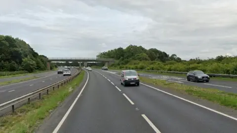 Google Cars driving along a stretch of dual carriageway, with another car driving on a slip road.