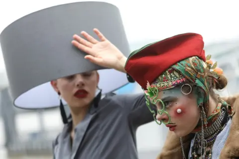 Simon Dawson/Reuters Participants pose for photographs as they take part in a Hat Walk