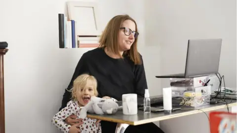 Getty Images Woman trying to work from home with small child