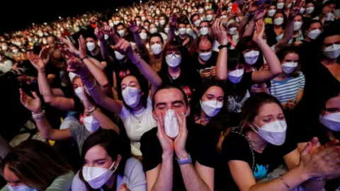 Reuters Masked music fans at the concert