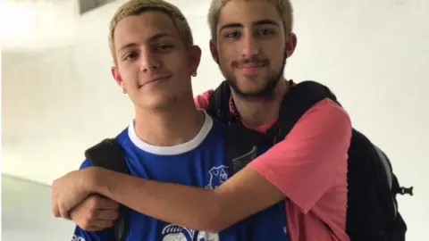 Ross Rosenzweig /Facebook Two teenage boys hug each other and grin broadly