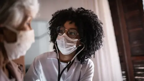 Getty Images A doctor in a mask wearing a stethoscope