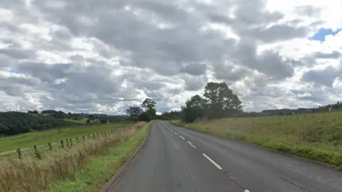 The A6 is a winding rural road, which has two lanes. It is surrounded by grassland. 