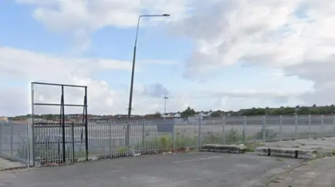 Google An open area of land behind fencing