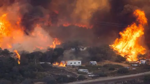 Getty Images Fires rage near a highway in California in December 2017.