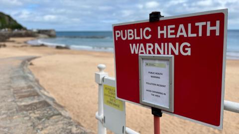 Close up of public health warning sign at beach