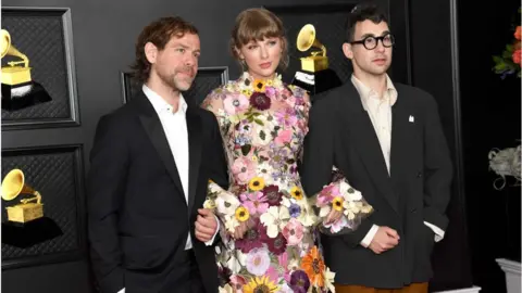 Getty Images Bryce Dessner, Taylor Swift and Jack Antonoff at the Grammy Awards, after winning album of the year for Folklore in 2021