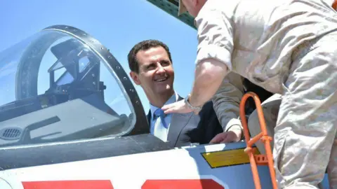 AFP President Bashar al-Assad sits inside a Su-27 jet during a visit to the Hmaimim military base in Latakia province, Syria (27 June 2017)