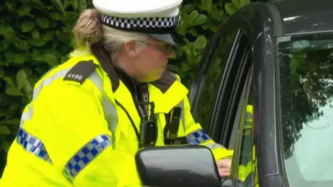 BBC An officer speaking to a driver