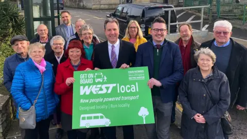 LDRS Image of Dan Norris and local residents. Mr Norris is holding a green sign which promotes the WESTlocal scheme.