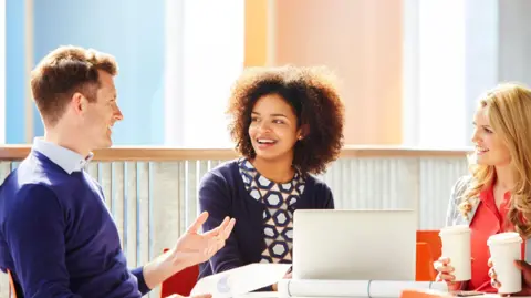 Co-workers discussing project over coffee - stock photo