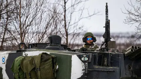 A Finnish soldier of the Finnish-Swedish Division rides the Leopard 2A6 battle tank, during a demonstration of border crossing by Swedish and Finnish troops as part of the NATO Nordic Response 24 military exercise 