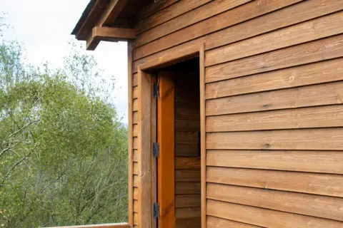 Getty Images A wood framed cabin viewed from close up