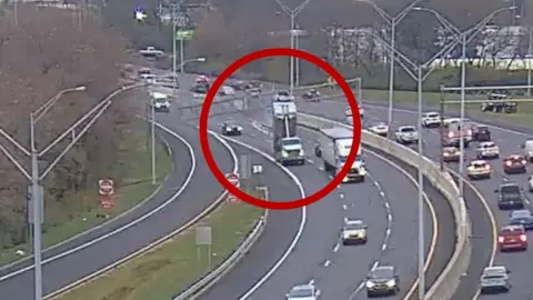 A truck can be seen hitting an overhead sign, circled in red.
