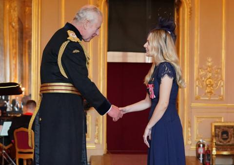 Lissie Harper receiving her MBE from King Charles