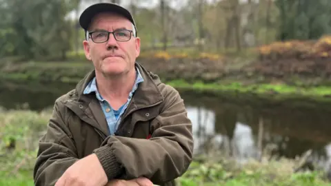 Campaigner Simon Walters standing by the bank of the River Cleddau