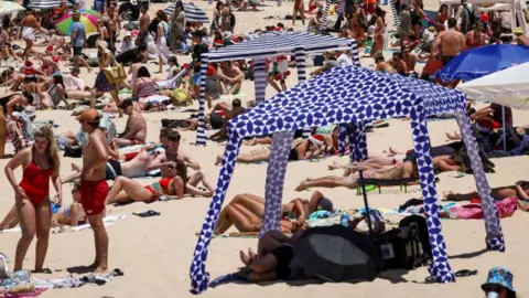 Beachgoers are seen on the sand on Christmas Day at Bondi Beach in Sydney on December 25, 2024.