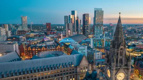 Manchester City Council An aerial view of the Manchester city centre skyline during the day.