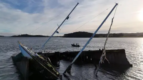 A half sunken ship sticking out of the water in Strangford Lough
