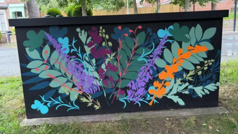 Supplied/LDRS A black utility box with brightly coloured leaves painted all over it.