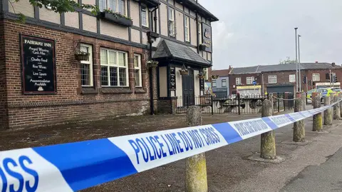 Police tape cordoning off the Fairway Inn pub in New Moston.