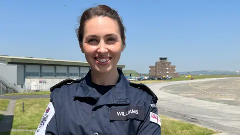 Petty Officer Megan Williams wears a Royal Navy uniform and smiles into the camera