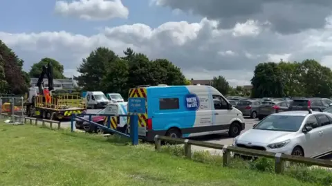 Southern Water vans in a car park with tankers and workmen dressed in orange.