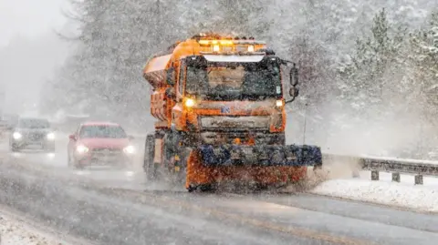 PA Media Cars follow gritter vehicle as it clears snow and ice in Inverness