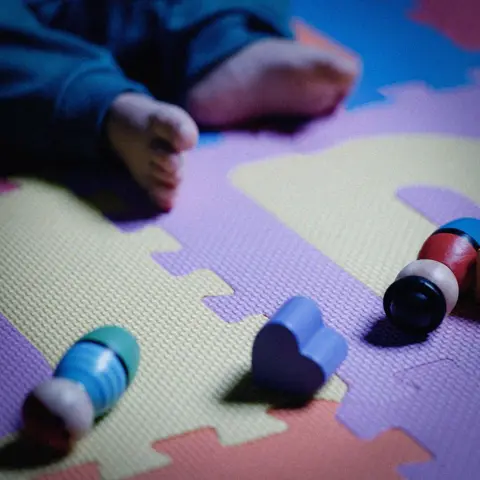 Getty Images A child by some wooden toy figures