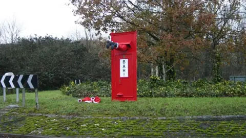 IMPRO Father Christmas stuck in postbox