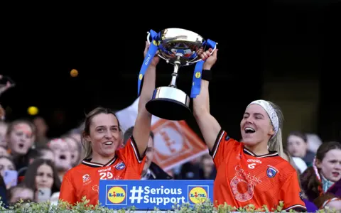 Armagh's Eve Lavery and Lauren McConville lift the National Football League Division 1 trophy last month.