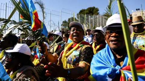 Reuters Christian worshippers carry the national flag of the Democratic Republic of Congo as they attend a Palm Sunday procession on the Mount of Olives in Jerusalem April 2, 2023