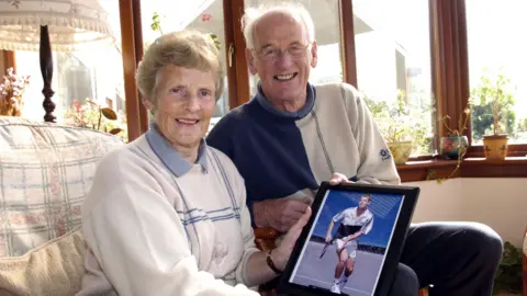 Roy and Shirley Erskine holding a photo of Andy Murray after his victory in the 2004 Junior US Open