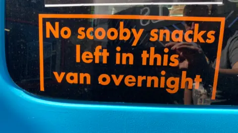 A sign in the vehicle's window says; "No Scooby snacks left in this van overnight".