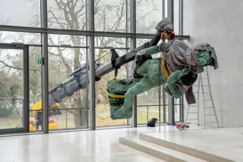 Ida Marie Odgaard/Ritzau Scanpix/AFP The statue David is lifted by crane through a large window of the National Gallery of Denmark. The statue is on its side, partially covered in a grey drape, as it is moved through the window