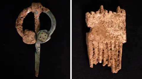 A composite image of artefacts found in medieval cemetery, on the left is a green almost circular metal brooch with a long pin, on the right is a fragment of a comb with broken teeth that has been carved from antler. 
