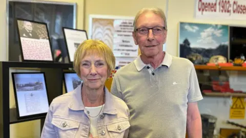Dennis Page and Jennifer Thornley stood inside the Nottinghamshire Mining Museum in Mansfield, with the exhibition on wartime miners behind them.
