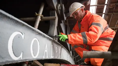 Aaron Chown / PA Conservation worker on the Iron Bridge