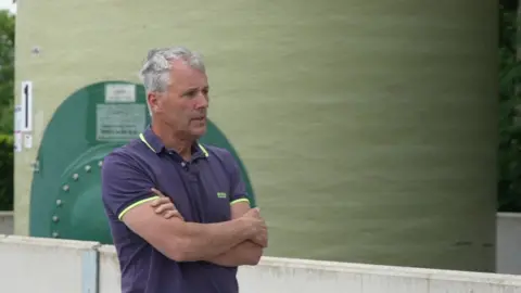 Andrew Ward standing in front of fertiliser container