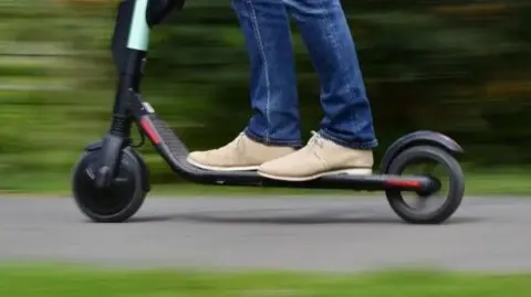 A person seen riding an e-scooter 