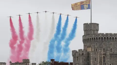 Reuters Nine red jets roar over Windsor Castle, emitting red, white and blue smoke.