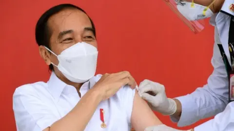 Reuters President Joko Widodo reacts after receiving a shot of COVID-19 vaccine at the Merdeka Palace in Jakarta, Indonesia, January 13, 2021.