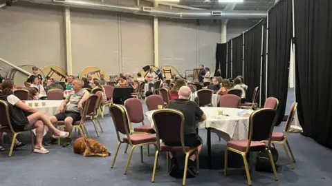 Anne Conlin people sitting round tables in a hall