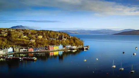 Colourful houses in Tobermory, Mull. There are boats moored in the bay opposite the town.