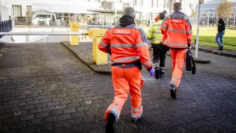 AFP/Getty Images Emergency rescue worker run to the court building in The Hague. Photo: 29 November 2017