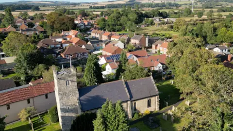 BBC A religion  and respective  houses successful  Shiptonthorpe tin  beryllium  seen from above. The prima   has formed  a shadiness   connected  the religion  and highlights antithetic  hues of greenish  wrong   adjacent    trees.