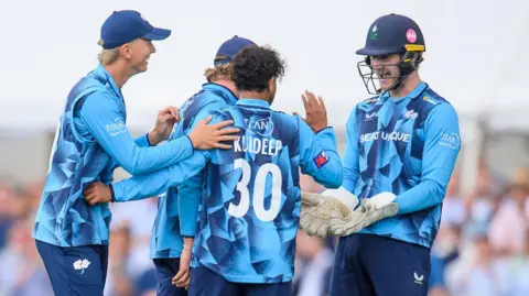 Yorkshire players, in blue shirts, celebrate with spinner Kuldeep Yadav after the dismissal of Ben Stokes