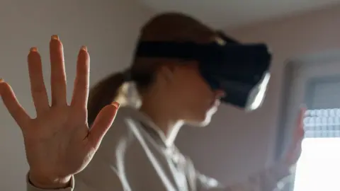 Getty Images Stock image of a girl, blurred, using a VR headset.